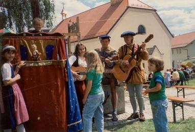 Musiker und Kinder vor einem Zirkuswagen